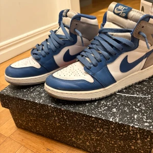 Nike Air Jordans i blått och vitt - Snygga Nike Air Jordans i en fräsch kombination av blått, vitt och grått. Skorna har klassisk snörning och en ikonisk design som passar perfekt för sneakerheads. Perfekta för att lyfta din stil till nästa nivå!