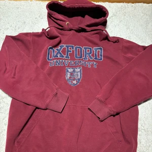  Oxford hoodie  - Säljer en vinröd hoodie med tryck av Oxford University. Bra passform för dig med M i storlek och väldigt snygg med vinröd färg