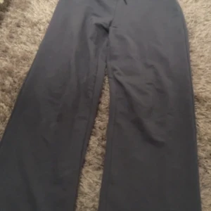 Mörkblå byxor - Säljer ett par mörkblå byxor med en rak och vid passform. Perfekta för en avslappnad stil. Byxorna har en enkel design utan synliga detaljer.