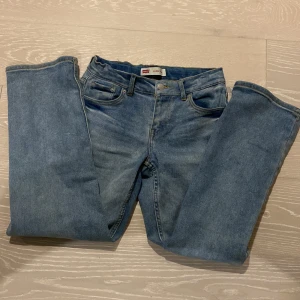 Blå jeans från Levi's - Säljer ett par klassiska blå jeans från Levi's med loose taper passform. De har en snygg vintage look med fem fickor och knappgylf. Perfekta för en avslappnad stil.