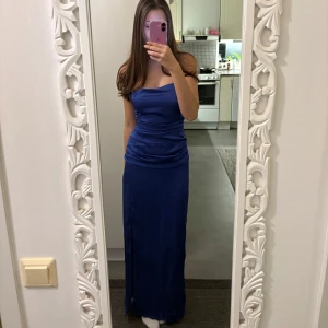 Blå balklänning - Superfin blå balklänning i storlek 38 (M) från Bubbleroom. Den har slits och knytning i ryggen. Bra skick!! Passar mig som egentligen har S i storlek, då knytningen i ryggen gör att man kan knyta den som man vill. Jag är 174cm som referens. Den är uppsydd av en sömmerska, men det är inget som ”syns” då det är gjort ordentligt