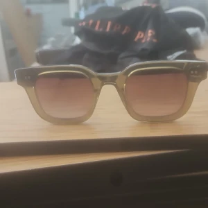 CHIMI 04. Gröna  solglasögon med fyrkantig form - Snygga solglasögon från CHIMI i transparent grön plast med fyrkantig form. Glasen är tonade i brunt och bågarna har coola silvriga detaljer på sidorna. Perfekt accessoar för att lyfta din stil och ge en modern touch till outfiten. storlek 04