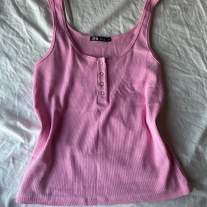 Rosa linnetopp från Zara - Supersöt rosa ribbad linnetopp från Zara med urringad halsringning och fyra silvriga knappar framtill💗Säljer den då den inte passar mig längre💗