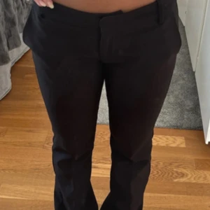 Svarta kostymbyxor  - Snygga svarta kostymbyxor med bootcut och klassisk passform.  Materialet känns mjukt och följsamt. Kostymbyxorna är från Bikbok något nopprigt på bak sidan