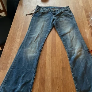 Blå bootcut jeans från Cross - Blå jeans från Cross, snygg passform med ljusare färg på benen för en ”sliten effekt”, jeansen är inte slitna över huvudtaget, då de inte är använda, bara testade❤️ små nitar/knappar som detaljer och snygga bakfickor❤️Jeansen är snygga och passar perfekt till nästintill allt❤️Som man ser på bilden sitter en etikett kvar❤️