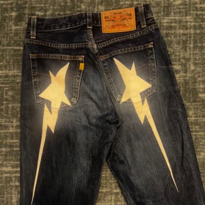  Jeans insperade Bape star  - Väldigt fint skick på de. Säljer för de inte kommer till användning. Målat designen själv. Väldigt coola. Mått: Midja: 34 Innerbenslängd: 84 Öppen för prisförslag! 
