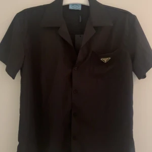 Prada Skjorta  - Kortärmad skjorta från Prada.                             Storlek M.                                                                          Använd några få gånger men har ej något tecken på användning, som nytt skick.                                         