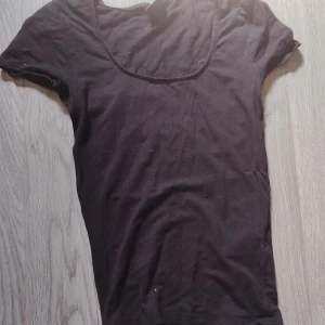 Svart topp från Gina Tricot XXS - Enkel svart topp från Gina Tricot i storlek XXS. Modellen har rundad urringning och korta ärmar. Perfekt basplagg att styla med jeans eller kjol. Mjuk och stretchig känsla, troligtvis i bomullsmix.
