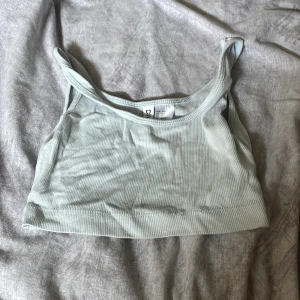 Ljusblå ribbad linnetopp  - Supersöt ljusgrön ribbad linnetopp från Gina Tricot. Croppad modell med smala axelband och stretchigt material som sitter skönt. Perfekt till jeans eller kjol när du vill ha en enkel men fräsch look.