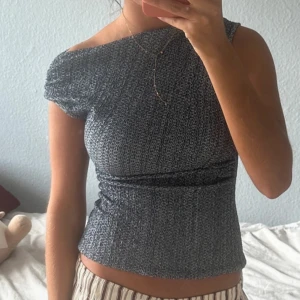 Mörkgrå offshoulder topp - Säljer en mörkgrå, tight offshoulder topp med kort ärm. Toppen