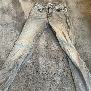 Gråa straight jeans från Perfect Jeans - Snygga grå jeans från Perfect Jeans i klassisk straight modell. De har fem fickor, bälteshällor och dragkedjegylf. Jeansen är i ett ljusgrått tvättat denimtyg som ger en cool vintagekänsla. Perfekta för dig som gillar en avslappnad men stilren look.