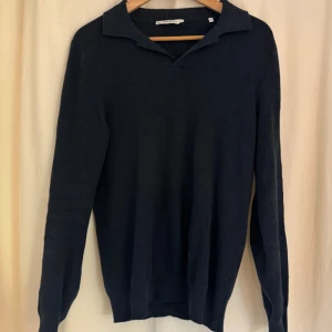 Mörkblå bomullströja från John Henric - Snygg mörkblå tröja från John Henric i 100% bomull. Tröjan har krage och lång ärm, perfekt för dig som gillar en stilren och klassisk look. Passar lika bra till jeans som till chinos. Enkel att matcha och superbekväm.