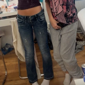 LTB jeans  - Säljer ett par blå jeans med bootcut-modell och snygga slitningar framtill. Jeansen har låg midja och klassiska fem fickor. Materialet är jeans i bomull och de har en cool, lite tvättad look. Perfekta för dig som gillar en avslappnad men trendig stil. Jag har sprättat upp långst ner så dom blev lite längre som man ser! 