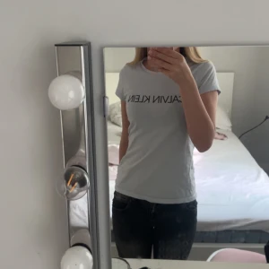 Ljusblå Calvin Klein t-shirt med tryck - Ljusblå t-shirt från Calvin Klein med svart logotyptryck framtill och litet 'JEANS'-märke baktill. Skriv om du har några frågor💗