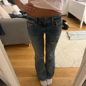 Blå bootcut jeans från American Eagle - Bra skick, själv är jag 167 och de är lite lite korta på mig men det funkar.   Har 32/34 i midjan och de sitter lite pösigt på mig 