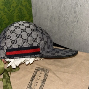 Gucci keps - En gucci keps i strl L passar även M riktigt sällsynt och snygg. Lite små skador på kepsen men de är inte synliga. Vid sidorna är de lite spräckta och små stygn som inte syns. Hör av er vid frågor