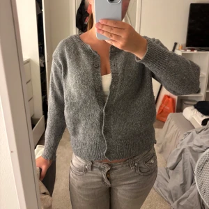 Grå kofta från SHEIN i stickad polyester - Mysig grå kofta från SHEIN i stickad polyester. Modellen har långa ärmar, ribbade muddar och knäppning framtill med fyra knappar. Perfekt för lager-på-lager och enkel att matcha med jeans eller kjol. Storlek xs, pris kan diskuteras 