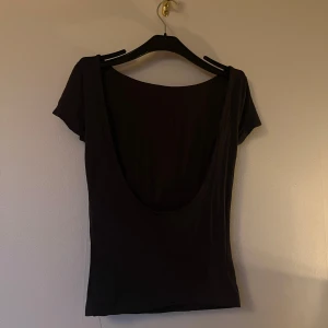 2-pack toppar med djup rygg, mörkgrå & vit - Två toppar i mörkgrått och vitt med kort ärm och djup, rundad rygg. Båda är samma modell från Ginatricot i storlek S. Det är även dubbelt tyg på framsidan, så de är stabilare och inte alls genomskinliga.🤍Säljer båda för 80kr, inte enskilt. Nästintill oanvända men lappen är bortklippt från den vita.