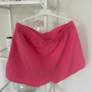 Rosa träningsshorts från SOC - Snygga rosa shorts från SOC i storlek S. De har elastisk midja med snörning och är gjorda i ett lätt och snabbtorkande material, perfekta för träning eller varma sommardagar. Enkel design utan mönster, riktigt sköna och lätta att röra sig i.
