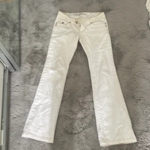 Vita bootcut jeans  - Snygga vita lågmidjade bootcut-jeans. Har fläckar som syns på bilderna, går nog att få bort i tvätten men annars så så snygga! Är 170 och de passar perfekt i längd, lite små i midjan därför säljs de.