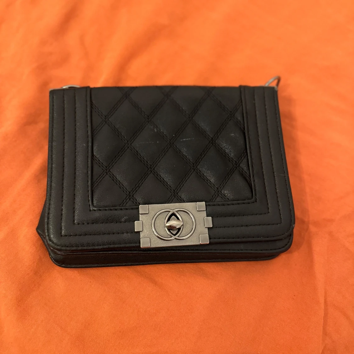 Svart quiltad axelväska med silverdetalj