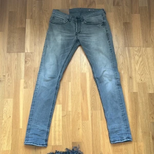 Grå jeans från DONDUP W31 L31 - Säljer ett par Grå jeans från DONDUP med klassisk femficksdesign. Jeansen har normal midja och är tillverkade i stretchigt denim för en tight passform. Perfekta för dig som gillar en smal siluett och streetinspirerad stil.