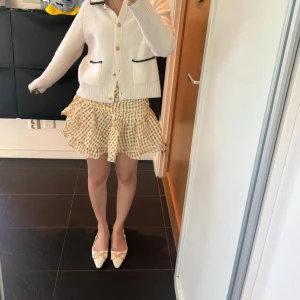 Gul och vit rutig volangkjol - Supersöt kort kjol i gul och vit rutig bomull med volanger. 