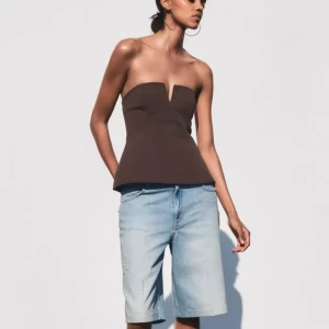 Brun axelbandslös tubtopp med V-ringning - Snygg brun tubtopp med markerad V-ringning framtill och figurnära passform. Jätte bra skick och fin topp från Zara 