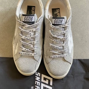 Glittriga sneakers från Golden Goose - Snygga sneakers från Golden Goose med silverglittrig ovandel. Skorna har använts i gott sick under en kort tid. Är köpa på Vestiaire Collective och jag har orderbekräftelse. Kontakta mig gärna vid frågor.