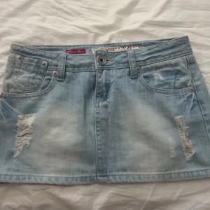 Lågmidjad jeanskjol 🥂 - Super fin ljusblå jeanskjol med slitningar som ej går att få tag i längre 💕 strl: 8 som motsvarar 36 men passar de mindre storlekarna som 32/34 då den är liten i strl. Defekt bild 4 - kedjan har gått sönder men går enkelt att fixa hos en makare billigt 💕 säljer vidare då den ej passade mig och vid några fler bilder, mått eller frågor är det bara att skriva 💕 Kan posta idag innan 17:00 och endast testad!!