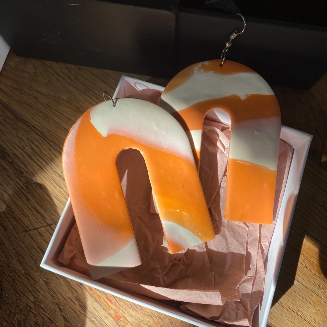 Stora orangevita bågformade örhängen