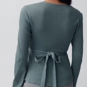 Grön topp  med knytband - Supersnygg grön topp med v-ringning och långa ärmar. Kommer ej t användning och har bara används en gång