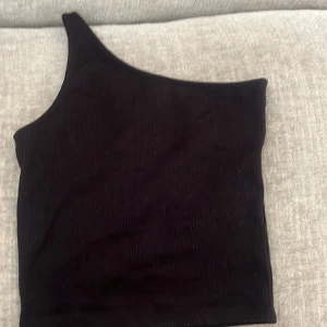 Svart oneshoulder topp Gina Tricot - Säljer en svart ribbad oneshoulder topp från Gina Tricot i storlek XXS. I bra skick💕
