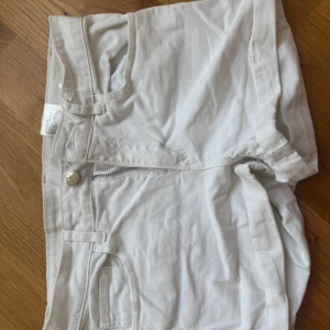 Vita shorts - Säljer ett par vita shorts med dragkedja och knapp framtill. De har fickor både fram och bak, vilket gör dem praktiska och stilrena. Perfekta för varma sommardagar!
