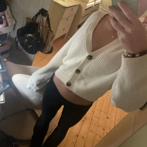 Vit ribbad kofta med knappar - Säljer en stilren vit ribbad kofta med knappar framtill. Koftan har en v-ringad design och långa ärmar, perfekt för en avslappnad look. Passar bra till både jeans och kjol. Hör av dig vid intresse! 🤍