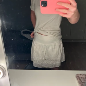 Vit kjol med broderade detaljer - Säljer en söt vit kjol med broderade detaljer och volang💕💕💕
