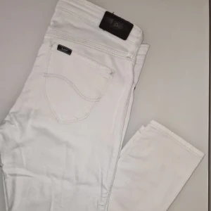Vita jeans från Lee - Vita jeans från Lee, perfekta för en stilren look. Märkesdetaljer på baksidan och knappen framtill ger en autentisk känsla. Använd 2 gånger och riktigt snygga till sommaren