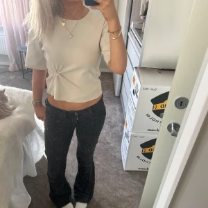 Beige/vit topp - Säljer denna topp i ett lite tjockare material. Sitter superfint o har en extra detalj på sidan. Typer fint skick, har inga defekter o är sparsamt använd!❤️‍🔥