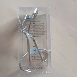 Ögonfransböjare från Make Up Store - Snygg och ergonomisk ögonfransböjare från Make Up Store. Den har en kontrollerad greppdesign och en böjd silikonplatta för att skydda fransarna. Perfekt för att skapa vackert böjda fransar med ett enkelt tryck. Helt ny, säljer då jag använder en annan och denna bara ligger i en låda