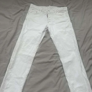 Vita jeans från Dsquared2 - Säljer ett par vita WHITE BULL Dsquared2 Jeans. De har en klassisk femficksdesign och knappar i gylfen. Perfekta för en stilren look. Perfekt att ha till sommaren! Säljes pga de inte passar just mig. Jeansen är som i nyskick, bara använts nåra enstaka gånger. Oerhört fräscha!! Storlek: 50