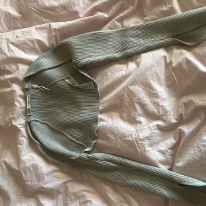 Grå ribbad kofta/bolero från Zara - Snygg grå ribbad kofta från Zara med långärmad design. Perfekt för lager-på-lager och att hålla sig varm under kyligare dagar. Enkel och stilren, passar till det mesta i garderoben.