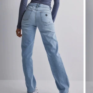 Ljusblå jeansbyxor från abrand  - Snygga ljusblå jeansbyxor med låg midja och rak passform. Perfekta för en avslappnad stil. Klassisk design med fem fickor och knappgylf.
