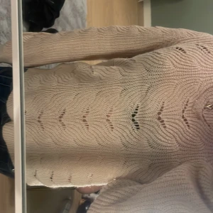 Beige stickad tröja från Neo Noir - Säljer en beige stickad tröja från Neo Noir med ett snyggt vågigt mönster. Tröjan har långa ärmar och en bekväm passform. Perfekt för att hålla sig varm och stilren. *köparen står för frakt*