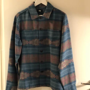 Mönstrad skjorta från WE - Snygg skjorta från WE i ett unikt mönster med blå och bruna nyanser. Skjortan har långa ärmar och knappar framtill. Perfekt för en stilren look.