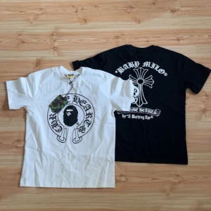 Chrome hearts x bape - Två stilrena t-shirts i svart och vitt. Båda har ett stort tryck med en ikonisk design på framsidan och baksidan. Perfekt för streetwear!