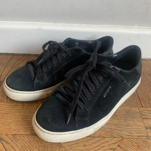 Svarta sneakers från Axel Arigato - Snygga svarta sneakers från Axel Arigato i mocka med vita sulor i storlek 39. Perfekta till våren och sommaren.