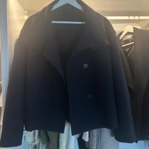 Svart kappa från Gina Tricot - Snygg marinblå kappa som är knappt använd. Skicket är som nytt säljer då jag har liknande. Galet snygg nu till våren😍😍