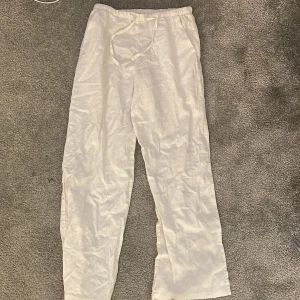 Vita linnebyxor från Gina Tricot - Säljer ett par vita linnebyxor från Gina Tricot. Byxorna har en elastisk midja med snörning för extra komfort. 