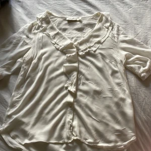 Vit blus - En jättefin vit blus med korta armar och volang detaljer. Passar jättebra till ett par jeans💗