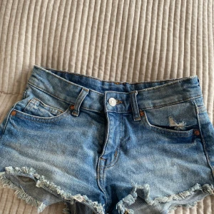 Blå jeansshorts med snygga detaljer - Säljer mina jeansshorts från h&m då de blivit för små! Jättensygg färg med fina detaljer! 